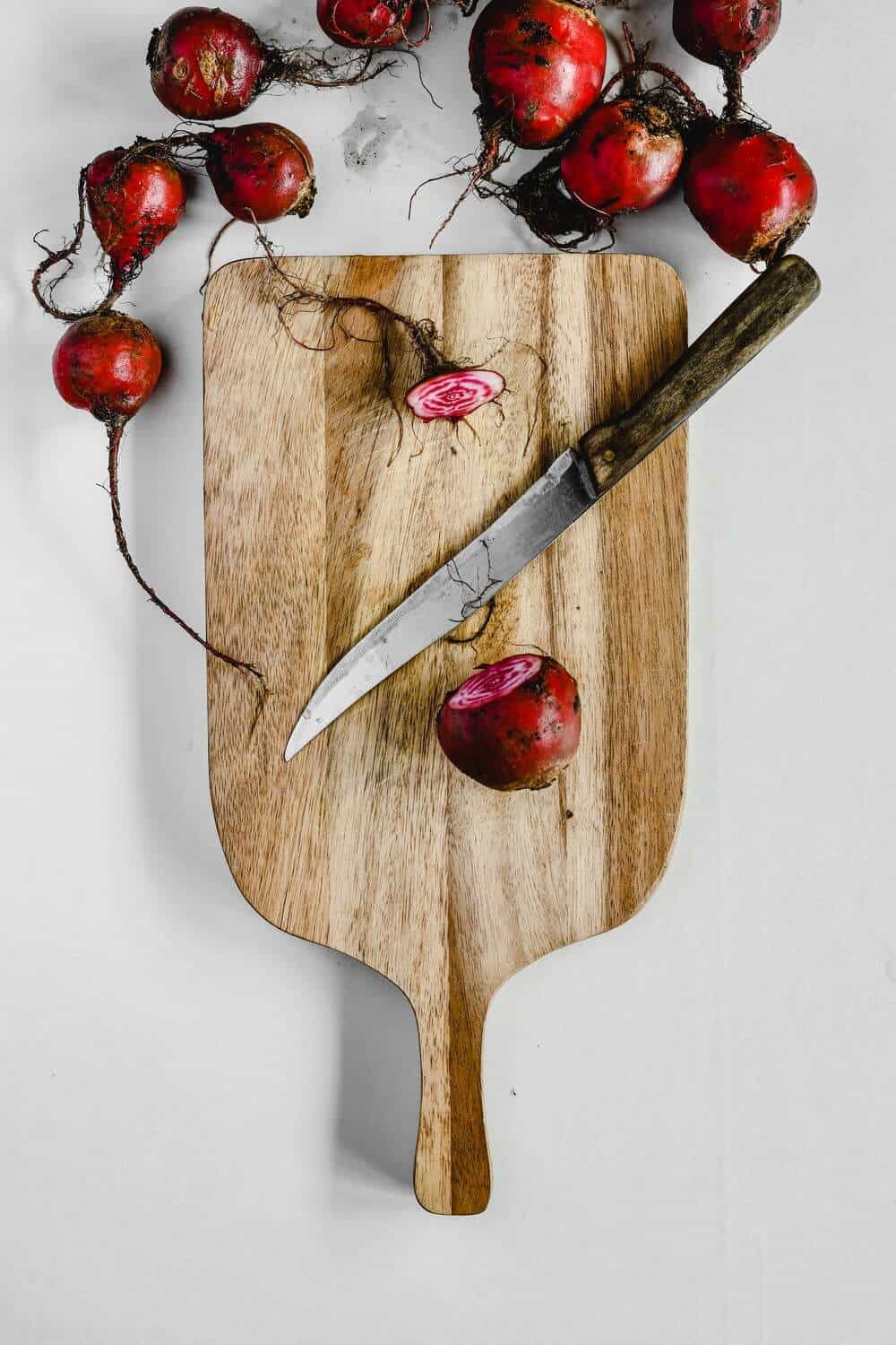 Beets on a wooden cutting board with a knife