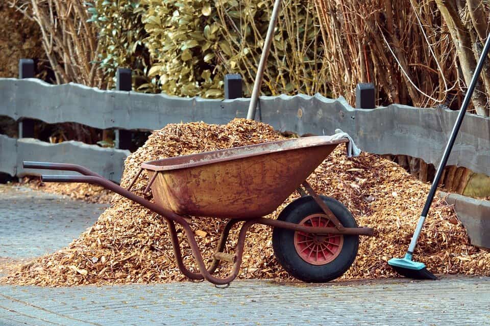 Mulch in a wheelbarrow with tools