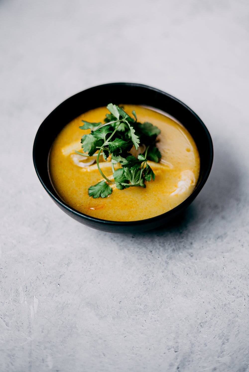 Orange soup in a bowl with parsley